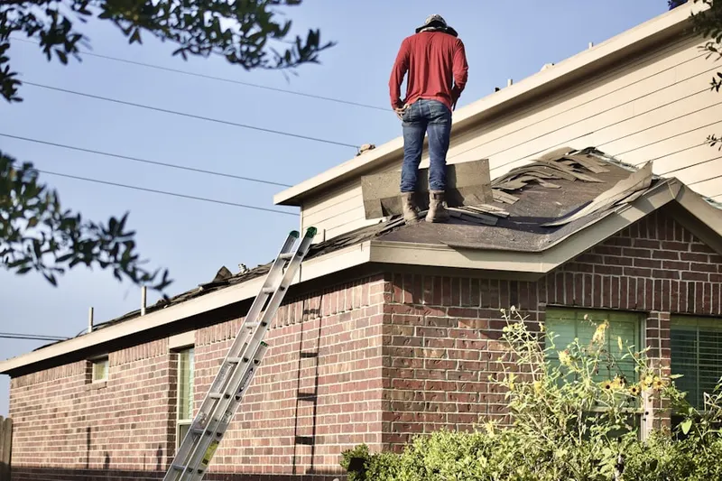 Professional roofer working on a residential roof in Phelps
